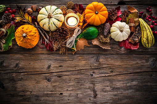 Autumn or Thanksgiving decoration border with mini pumpkins and dry leaves. Copy space