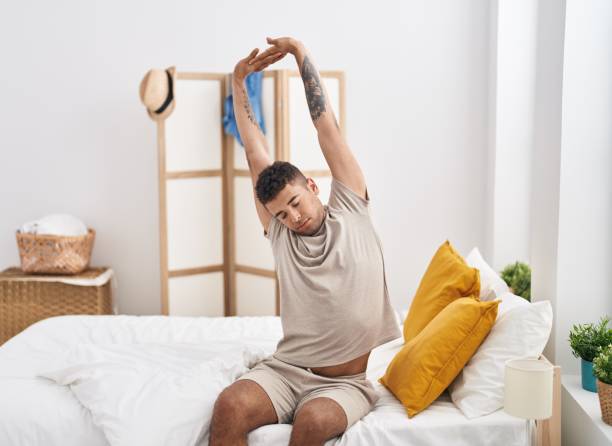 istock African american man waking up sitting on bed at bedroom 1436390835