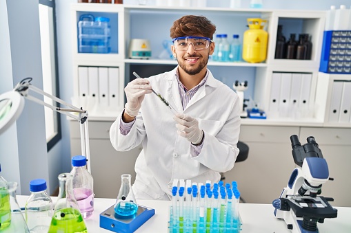 Young . man scientist analysing plant test tube at laboratory