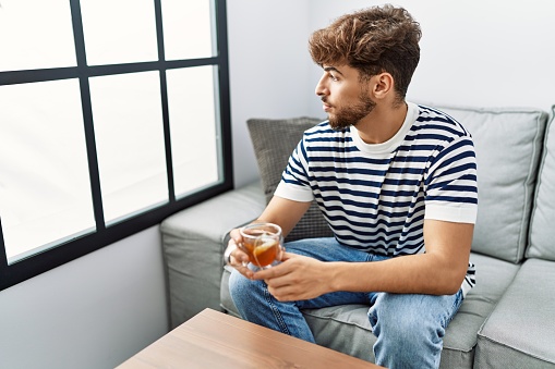 Young . man smiling confident drinking tea at home