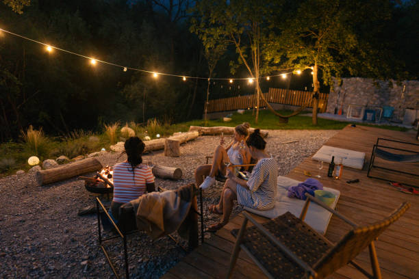 istock Female friends relaxing by the campfire and drinking wine 1436391639