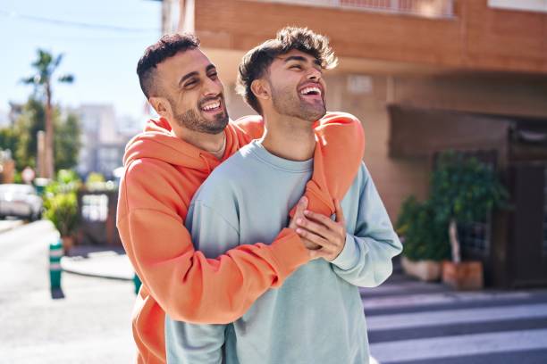 Two man couple hugging each other standing at street Two man couple hugging each other standing at street gay man stock pictures, royalty-free photos & images