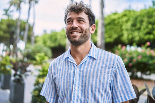 istock Young hispanic man smiling happy standing at the city. 1436395547