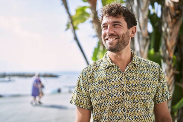istock Young hispanic man smiling confident walking at seaside 1436395564