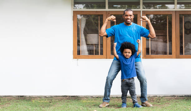African American Father and Afro boy doing strong gesture