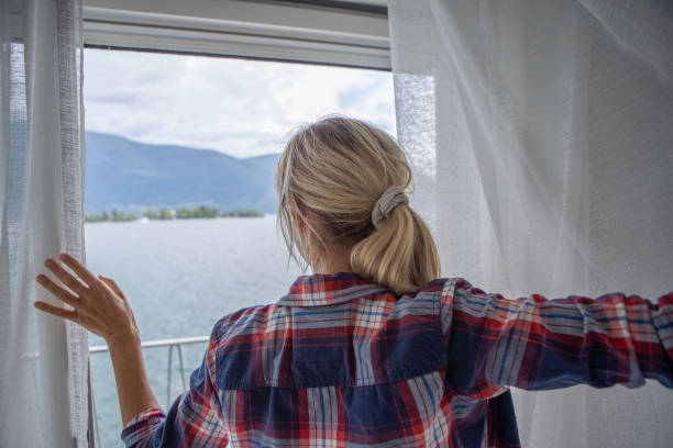 istock Woman opening curtains in room 1436401089