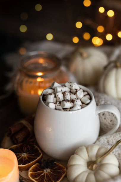 istock Autumn cozy home composition with hot chocolate with marshmallow and candles. Aromatherapy on a grey fall morning, atmosphere of cosiness and relax. Wooden background, window sill, close up. 1436402795