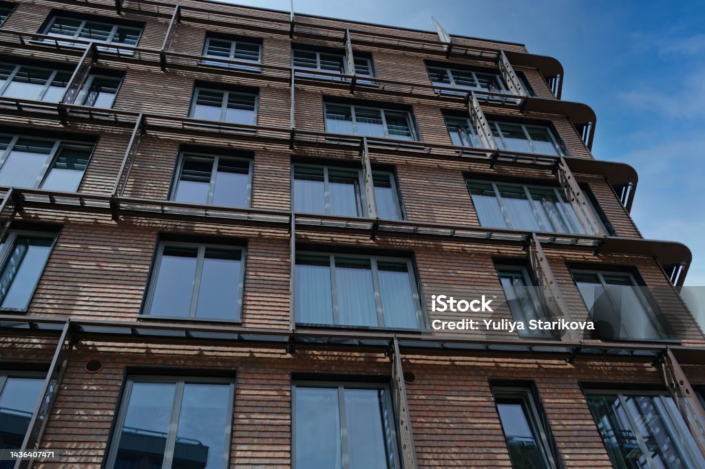 Exterior of modern red brick house with metal inserts. Architectural detail of close-up on windows. Real estate, residential apartments and offices. Living apartments or office building architecture. Advertisement Stock Photo