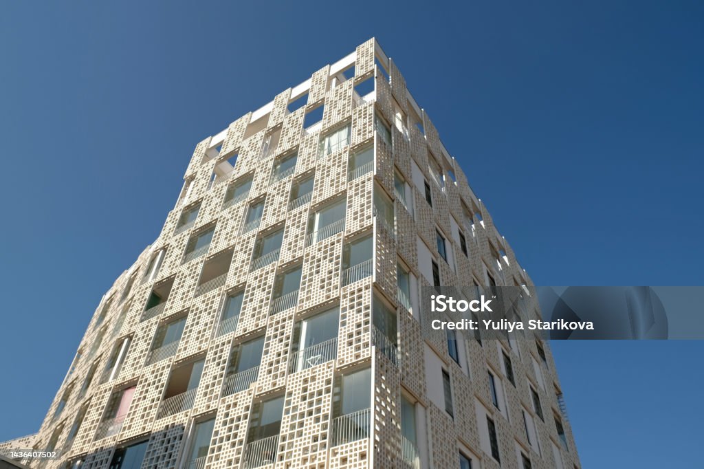 Exterior of modern white openwork house. Architectural detail of close-up on windows and texture wall. Real estate, residential apartment and office. Living apartments or office building architecture. Estonia Stock Photo