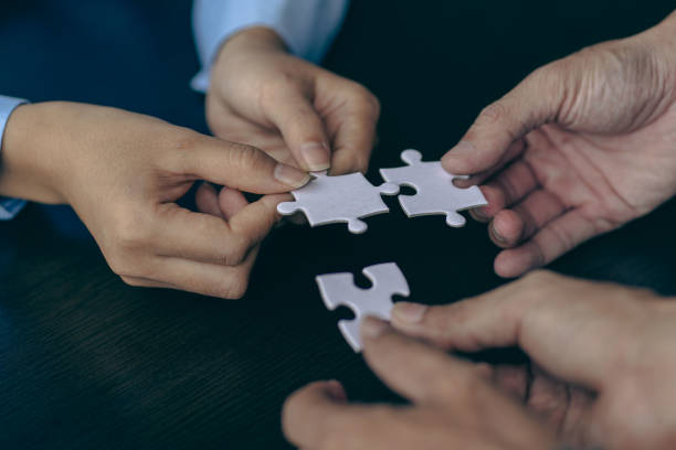 istock People holds in hand a jigsaw puzzle. Business solutions, success and strategy.Group of business people assembling jigsaw puzzle 1436408874