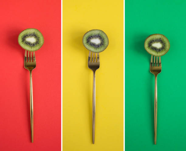 Collage of sliced kiwi impaled on a gold fork on the colored background. Top view. Close-up.