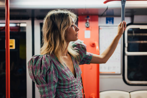 An Attractive Woman Looking Away While Standing In The Underground Train
