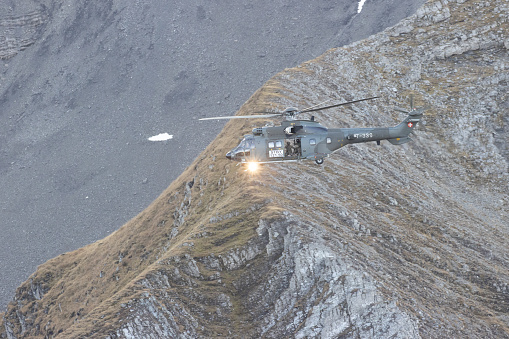 Military helicopter flying over the mountain peaks. 3d Rendering Aircraft. Aerial Landscape from British Columbia, Canada.