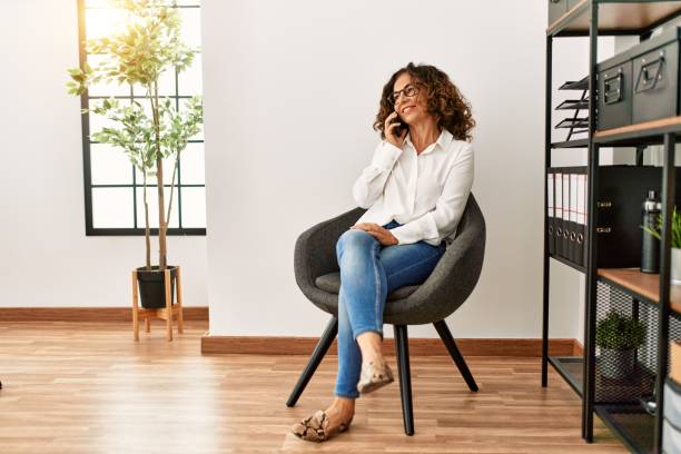 istock Middle age hispanic woman smiling confident talking on the smartphone at office 1436413826