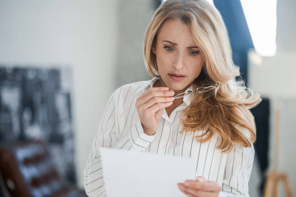 istock Blonde woman reading something and looking upset 1436415119