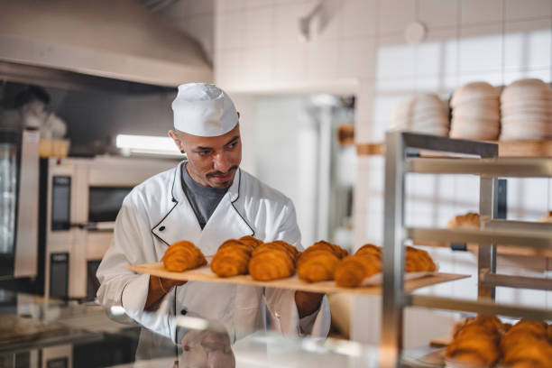 istock Baker Looking At Freshly Made And Delicious Croissants In His Bakery 1436415191