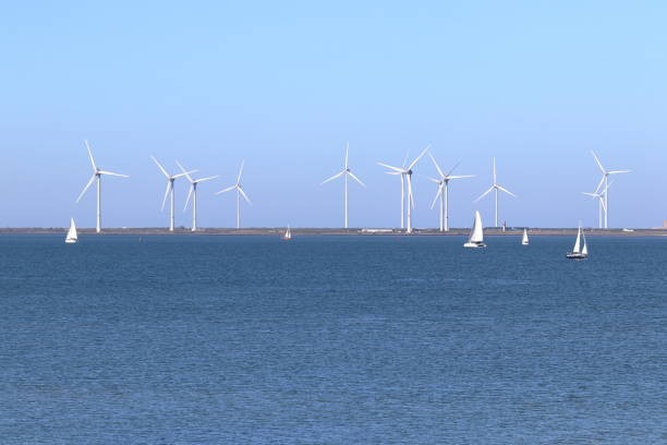 Wind power: sailing ships on the Eastern Scheldt estuary and wind turbines on the storm surge barrier, Netherlands