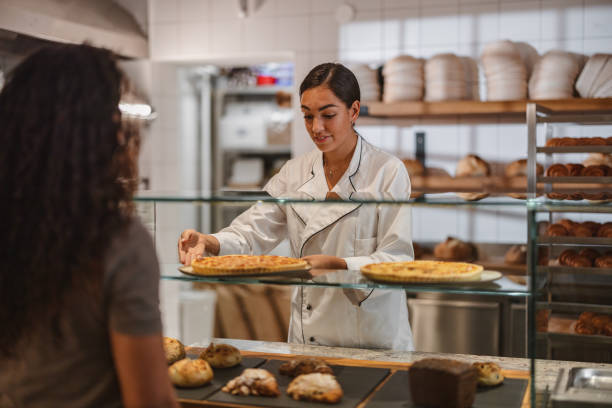 istock Hispanic Chef Serving Delicious Bread In His Bakery Shop 1436415898