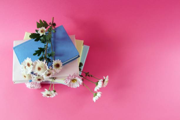 istock A stack of books with bookmarks from fresh chrysanthemum flowers, on a pink background, the concept of education, back to school 1436417961