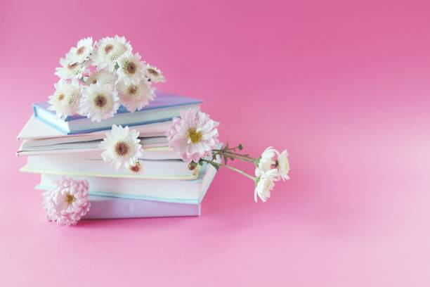 istock A stack of books with bookmarks from fresh chrysanthemum flowers, on a pink background, the concept of education, back to school 1436417981