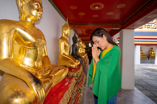 Woman travel in Bangkok Thailand. Wat pho temple, public place for praying budda. Affordable Travel concept.