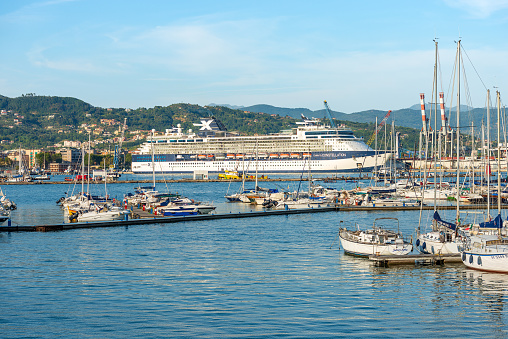 La Spezia, Italy - July 28, 2022: International port of La Spezia with a large cruise ship (Celebrity X Cruise, Celebrity Constellation) on a sunny summer day. Gulf of La Spezia, Liguria, Italy, Europe. Celebrity X Cruise is a luxury cruise company with a destination in the Mediterranean Sea and around the world.