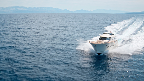 Aerial view of luxury yacht cruising in sea during sunny day.