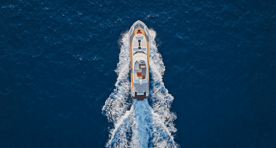 Aerial view of modern luxury yacht cruising in sea during sunny day.