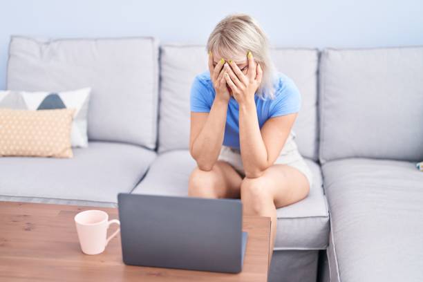 istock Young blonde woman stressed sitting on sofa at home 1436421113