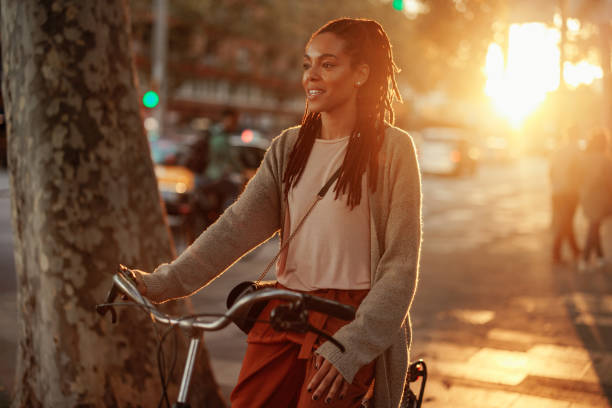 African American woman with bicycle in city. stock photo