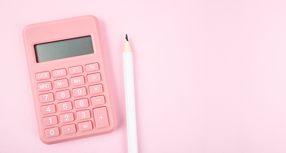 Top view pink calculator on pink background with copyspace for counting and planning about monthly expenses concept.