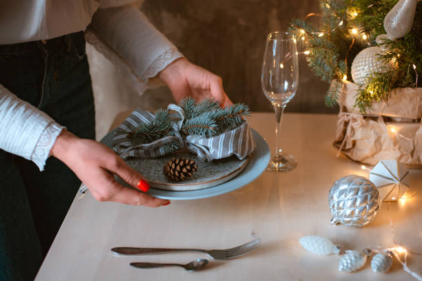 istock young woman decorates and sets a festive Christmas table with a spruce composition 1436425403