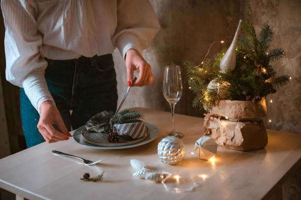 istock young woman decorates and sets a festive Christmas table with a spruce composition 1436425404