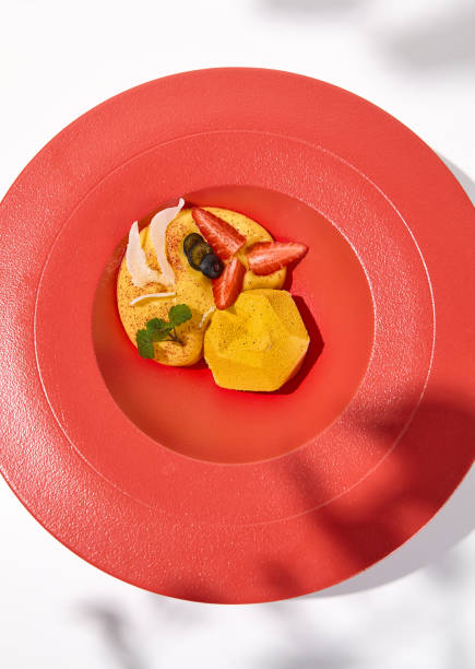 istock Yellow mousse cake in contemporary style on white background. Passion fruit cake with mango mousse and berries. Yoghurt cake with passion fruit on restaurant plate Light mousse dessert 1436425756