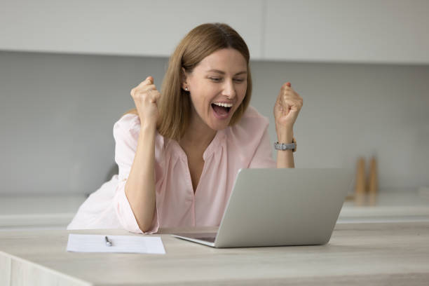 istock Woman looks at laptop scream with joy while read news 1436427140