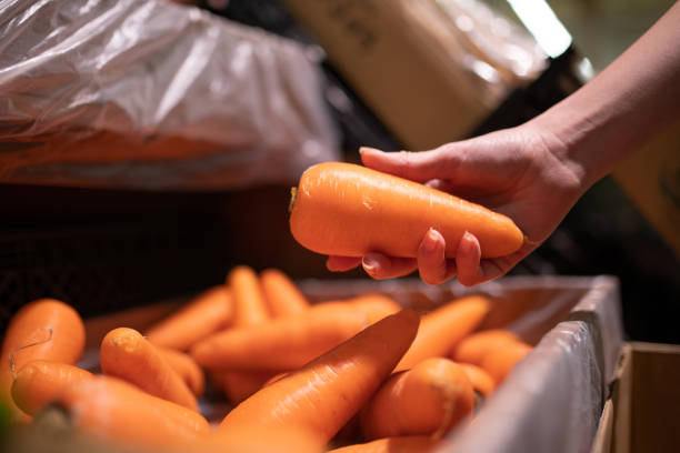 istock Woman's hand choosing carrots in supermarket 1436429255