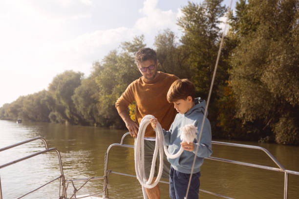 istock Father and son on a boat, sailing on the river 1436433360
