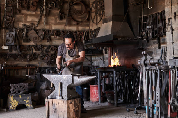 Man, hammer or iron anvil in blacksmith manufacturing, steel workshop or industrial metal production factory. Worker, manual labour or foundry industry plant engineering in product design forge labor hombre, martillo o yunque de hierro en la fabricación de herrería, taller de acero o fábrica industrial de producción de metales. trabajador, mano de obra o industria de fundición ingeniería de plantas en el diseño de productos forjar mano de obra