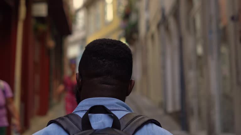 Traveller man walking in the city. Rear view.