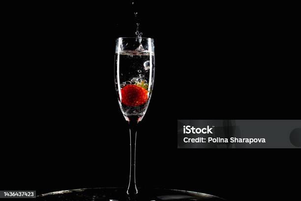 Red Strawberry Falls Into A Glass With Splashes On A Black Background Stock Photo - Download Image Now