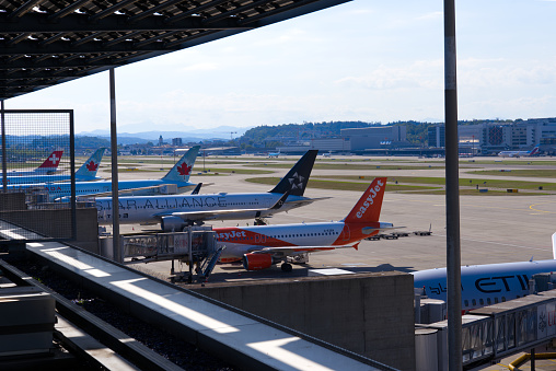 Parked transatlantic airplanes at Dock Midfield at Zürich Airport on a sunny summer day. Photo taken August 1st, 2022, Zurich, Switzerland.