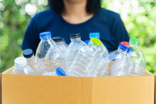 istock woman sorting garbage, holding carton box full of plastic bottles for preserving saving environment nature protection,Concept of reuse, reduce, recycle to save the environment. 1436438741