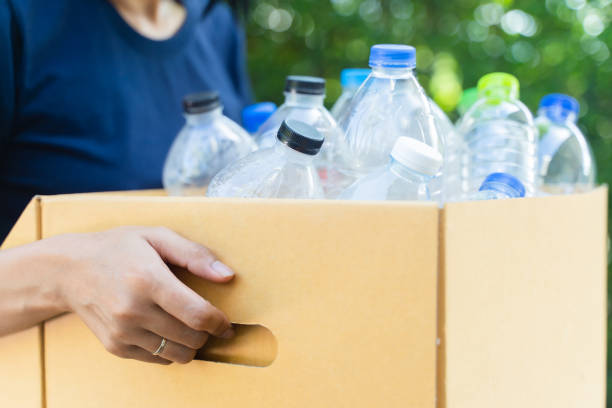 istock woman sorting garbage, holding carton box full of plastic bottles for preserving saving environment nature protection,Concept of reuse, reduce, recycle to save the environment. 1436438771