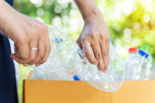 istock Hand hold and crushing plastic bottle for recycle.In garden background. 1436438774