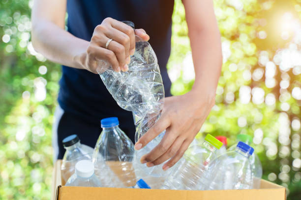 istock Hand hold and crushing plastic bottle for recycle.In garden background. 1436438778