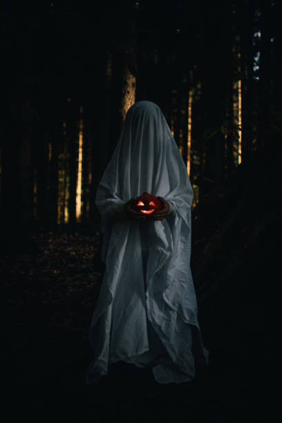 istock A child in a white sheet with a pumpkin Jack in his hands depicts a ghost 1436440217