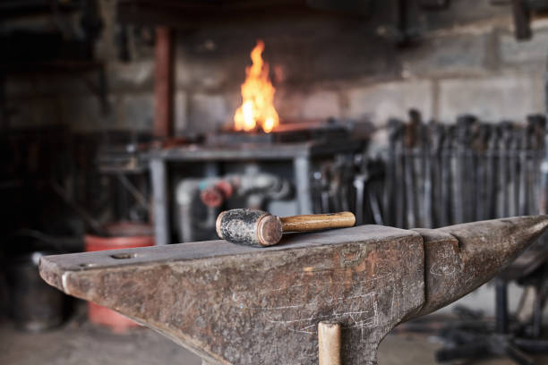 istock Hammer, iron anvil or blacksmith tools in manufacturing workshop, factory product engineering or metal production. Zoom, foundry or industry equipment in fire forge or steel welding industrial design 1436445432