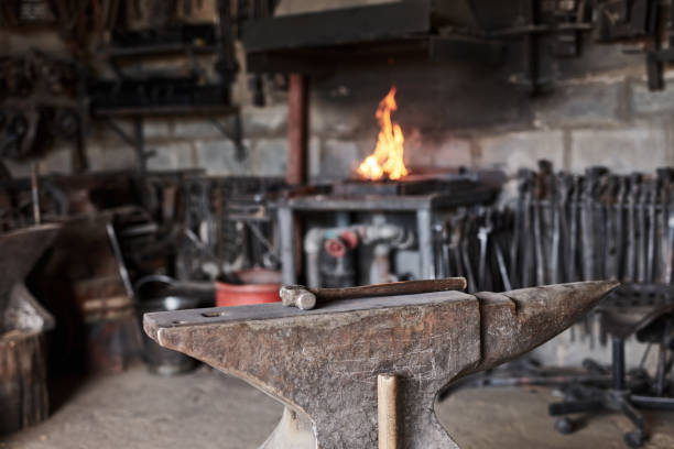 istock Iron anvil, manufacturing workshop and hammer in blacksmith factory, engineering or metal product production. Zoom, texture and foundry industry to forge steel, welding or industrial design with fire 1436445434