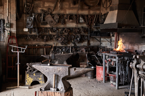 Welding workshop, fire and tools in an industrial warehouse with tools and equipment for steel manufacturing. Workplace,  welder metal and anvil in a mechanical, blacksmith or engineering garage