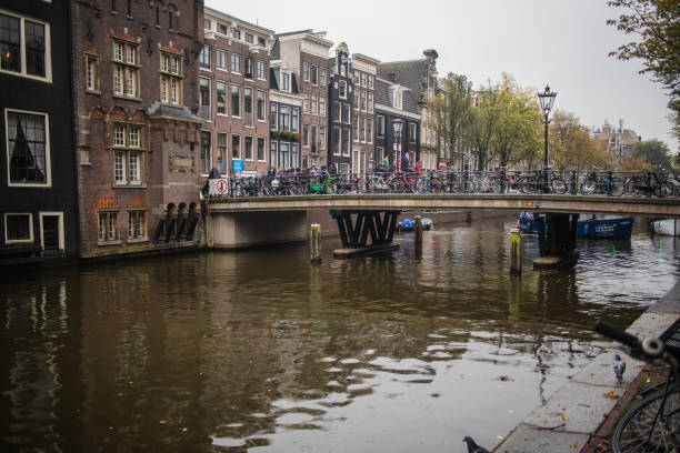 Views of Amsterdam in the Netherlands alongside bicycle life and architecture on a rainy Autumn day in October stock photo
